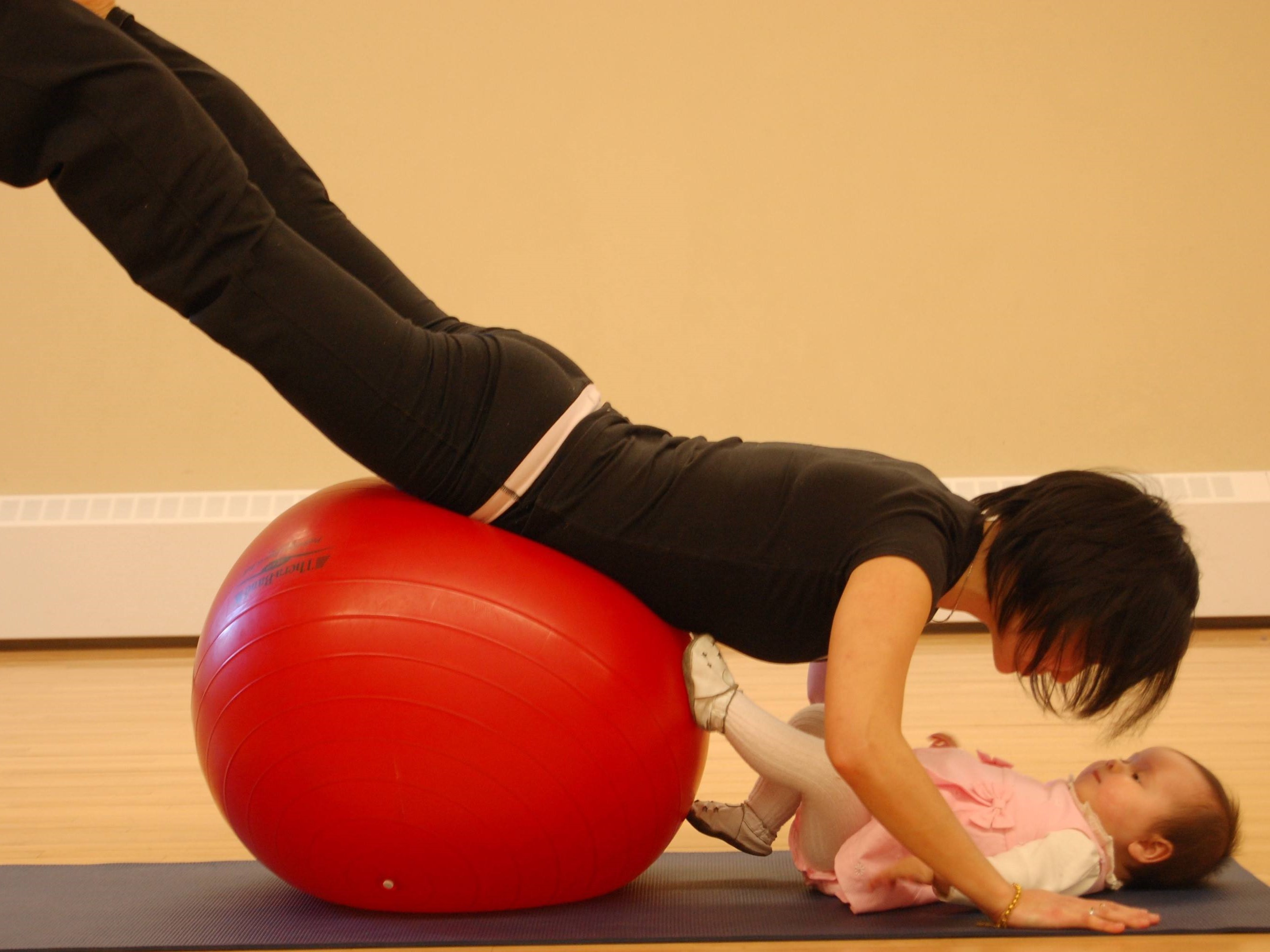 Woman doing ball excercise with baby